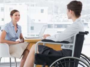 Businesswoman speaking with woman with disability